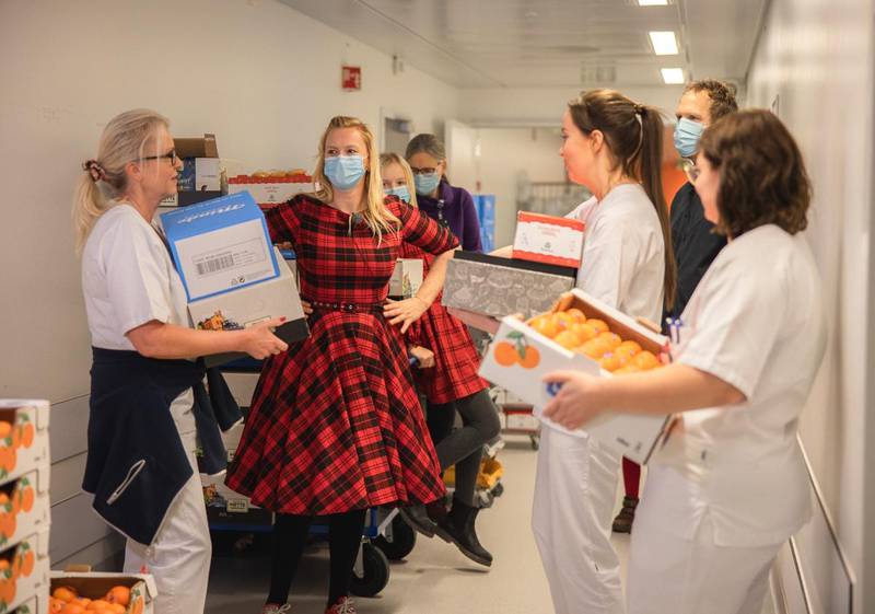 Giverglede: Over 500 mennesker har bidratt til julegave til helsearbeiderne. Initiativtager Sara Johannessen Meek, i rød kjole, deler ut gavene på vegne av giverne.