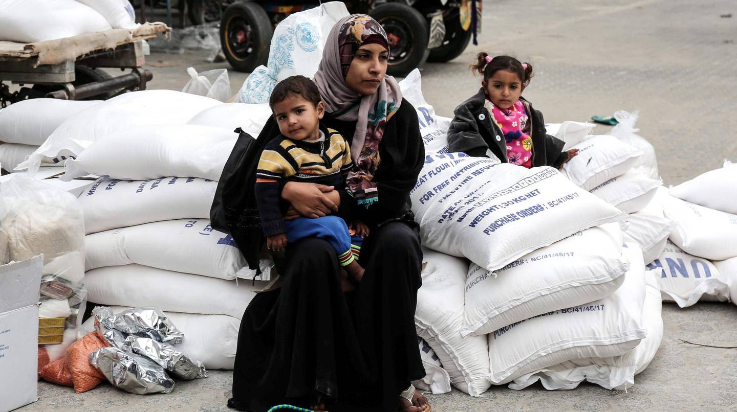 FN-organisasjonen UNRWA deler blant annet ut mat til palestinere i Gaza. Her en kvinne og hennes barn i Khan Yunis-flyktningleiren på  Gaza-stripen.