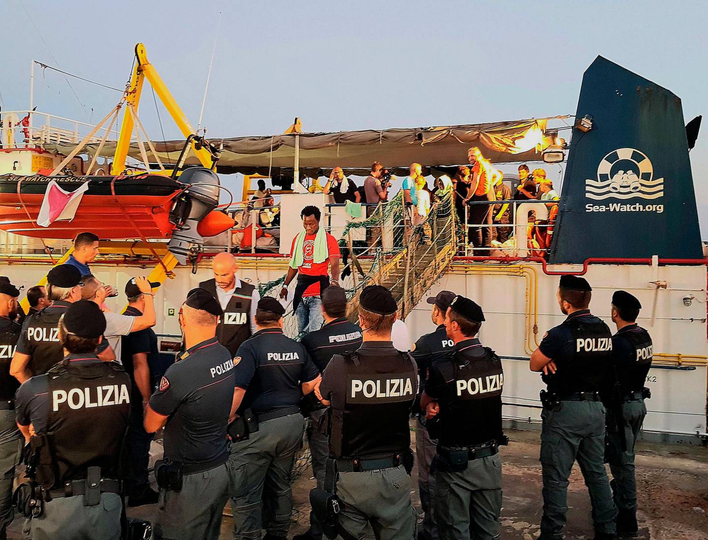 Migrants disembark from the Ducth-flagged Sea-Watch 3 ship, at Lampedusa island's harbor, Italy, Saturday, June 29, 2019. Forty migrants have disembarked on a tiny Italian island after the captain of the German aid ship which rescued them docked without permission. Sea-Watch 3 rammed an Italian border police motorboat as it steered toward the pier on Lampedusa. (Elio Desiderio/ANSA via AP)