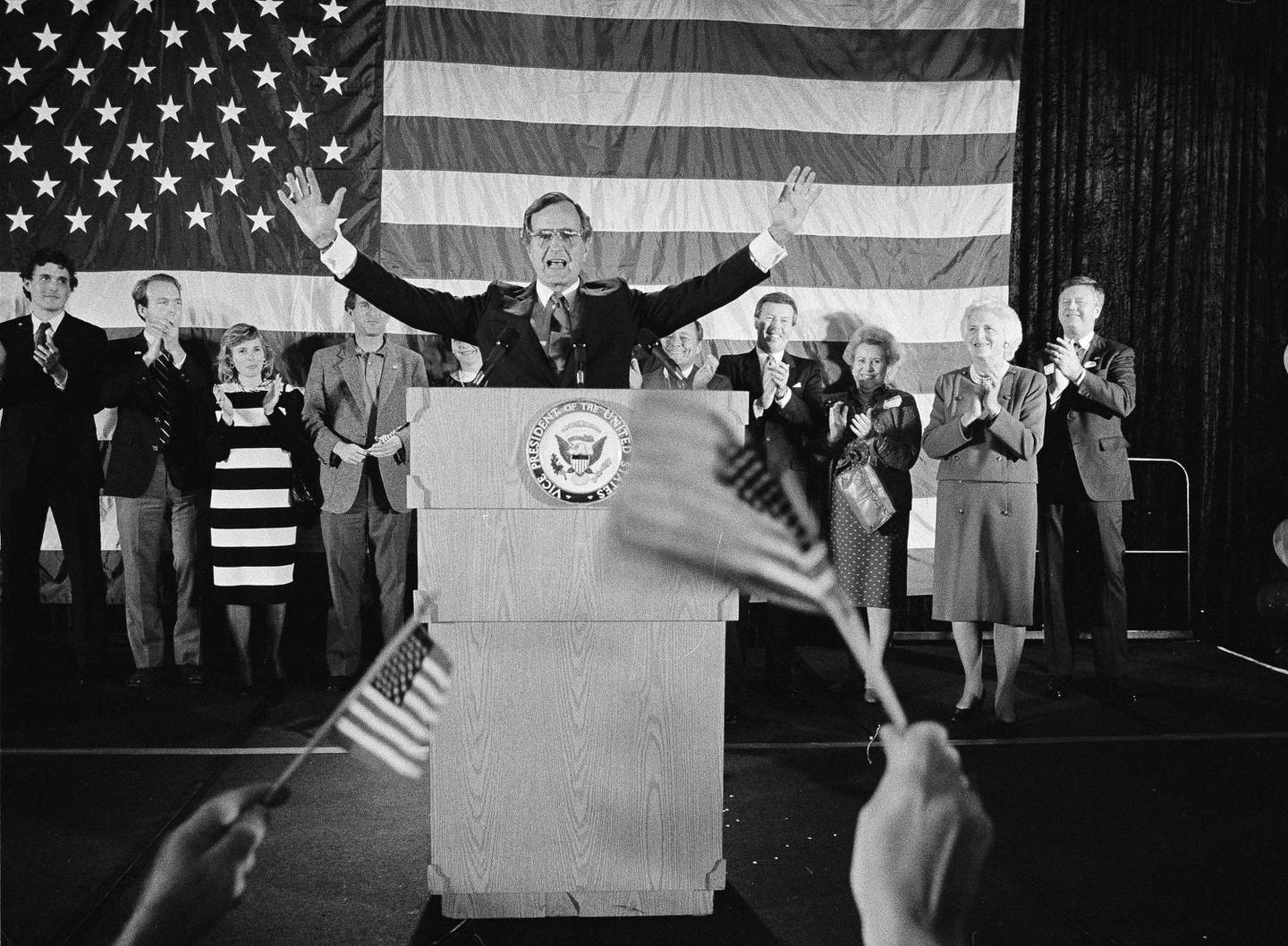 FILE - In this Nov. 7, 1984 file photo, flag-wavers greet Vice President George Bush after he was re-elected to the post of vice president, in Houston, Texas. The vice president's wife Barbara Bush is seen second from right. Others are unidentified. Bush has died at age 94. Family spokesman Jim McGrath says Bush died shortly after 10 p.m. Friday, Nov. 30, 2018, about eight months after the death of his wife, Barbara Bush. (AP Photo/F. Carter Smith, File)