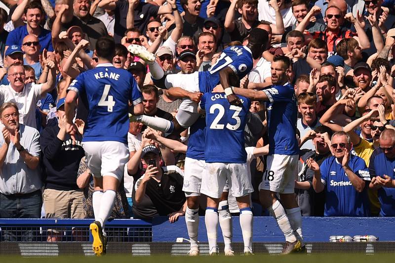Everton's English striker Theo Walcott celebrates with team-mates after scoring their fourth goal during the English Premier League football match between Everton and Manchester United at Goodison Park in Liverpool, north west England on April 21, 2019. (Photo by Oli SCARFF / AFP) / RESTRICTED TO EDITORIAL USE. No use with unauthorized audio, video, data, fixture lists, club/league logos or 'live' services. Online in-match use limited to 120 images. An additional 40 images may be used in extra time. No video emulation. Social media in-match use limited to 120 images. An additional 40 images may be used in extra time. No use in betting publications, games or single club/league/player publications. / 