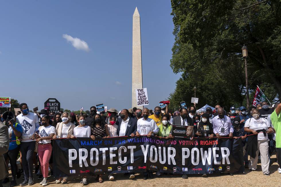 Demonstranter foran Washington Monument lørdag. Al Sharpton (i midten) holder et banner sammen med Martin Luther King III og demokratiske kongressrepresentanter. Foto: Jose Luis Magana / AP / NTB
