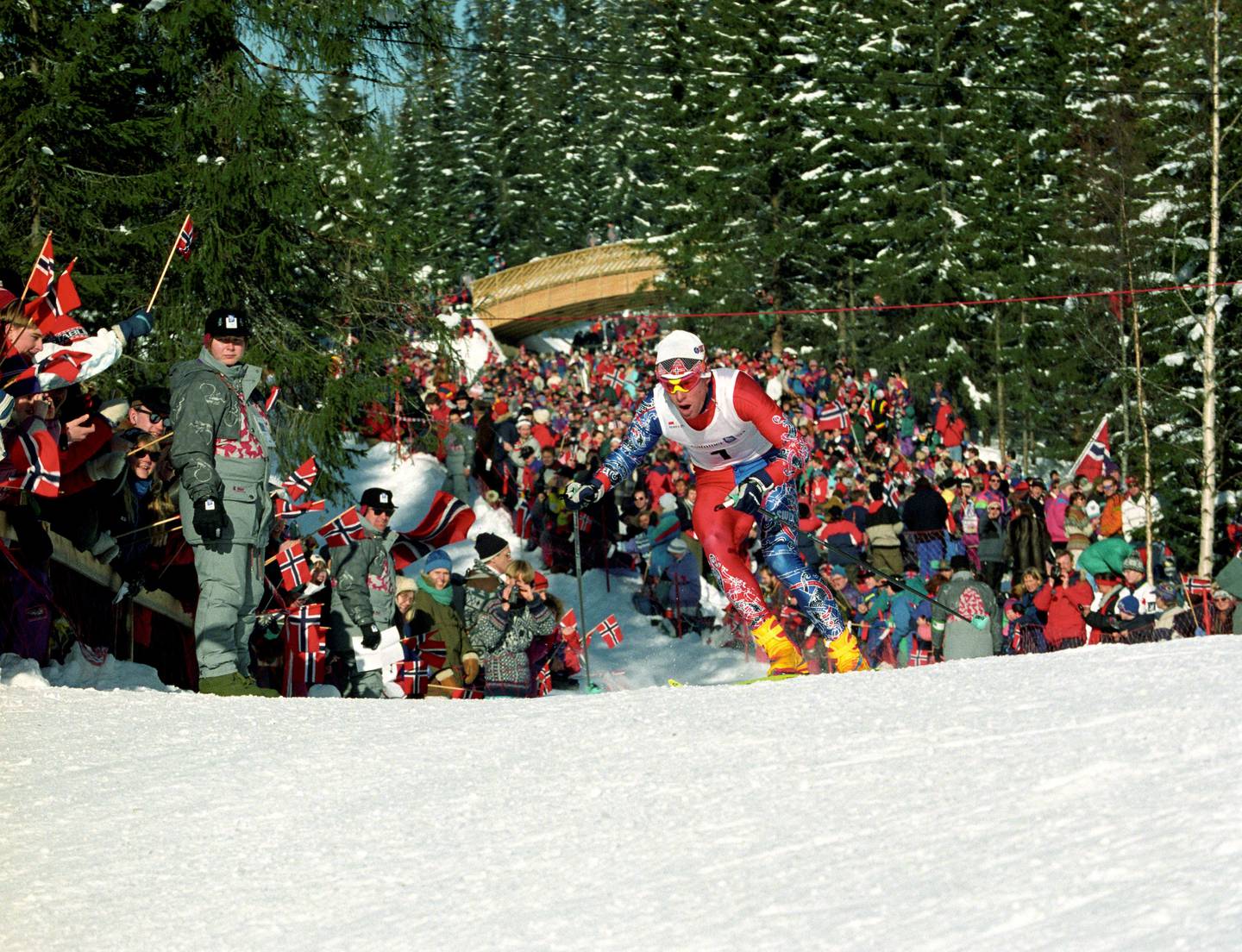 Lillehammer 19940219
Vinter-OL på Lillehammer
Langrenn, 15 km, jaktstart for menn.
Her, Bjørn Dæhlie i farta, han vant konkurransen.  Flere funskjonærer står langs løypa og passer på.
Foto: Jan Greve / NTB scanpix