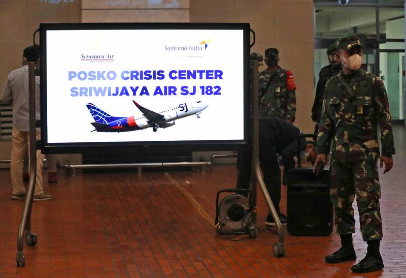 Indonesian soldiers stand near a crisis center set up following a report that a Sriwijaya Air passenger jet has lost contact with air traffic controllers after take off, at Soekarno-Hatta International Airport in Tangerang, Indonesia, Saturday, Jan. 9, 2021. The Boeing 737-500 took off from Jakarta and lost contact with the control tower a few moments later. (AP Photo/Tatan Syuflana)
