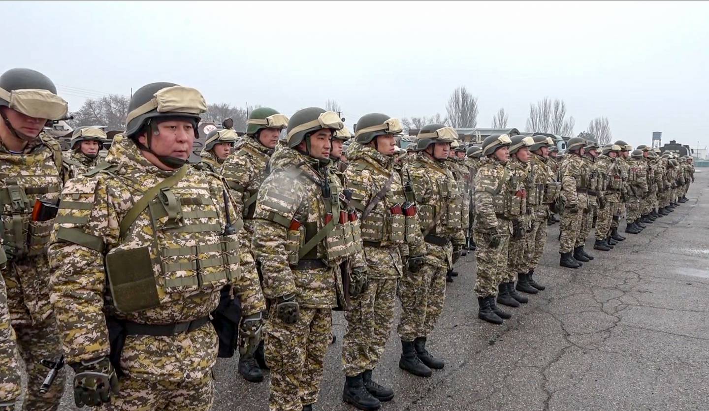 Soldater i kamuflasjeuniform og hjelmer står oppstilt på rekker