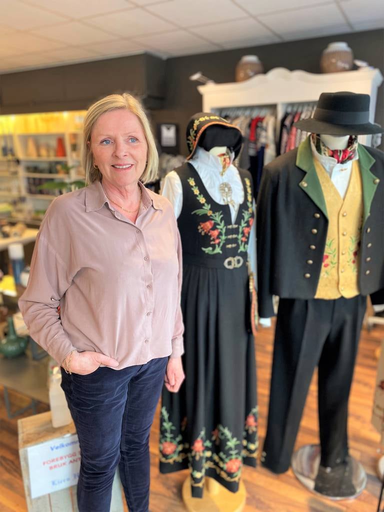 Daglig leder Grete Lier Jamissen ved Liers Husflid i Fredrikstad sammen med utstillingsmodeller av Løkenbunaden for både dame og herre.