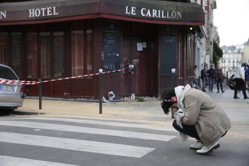 En ung kvinne sørger utenfor hotellbaren Carillon i Paris lørdag formiddag. Fredag ble minst 128 mennesker drept i et av de verste terrorangrepene i europeisk historie. FOTO: AFP/Francois Guillot