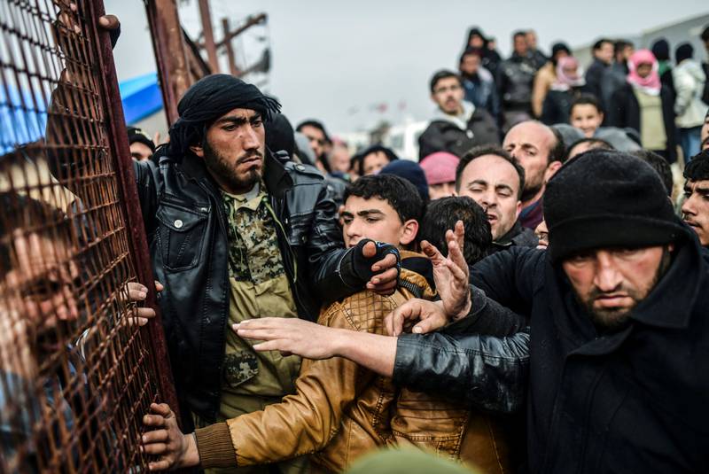 Flyktninger dytter hverandre mens de venter på telt ved Bab-al Salam nær den tyrkiske grensen. FOTO: BULENT KILIC/NTB SCANPIX