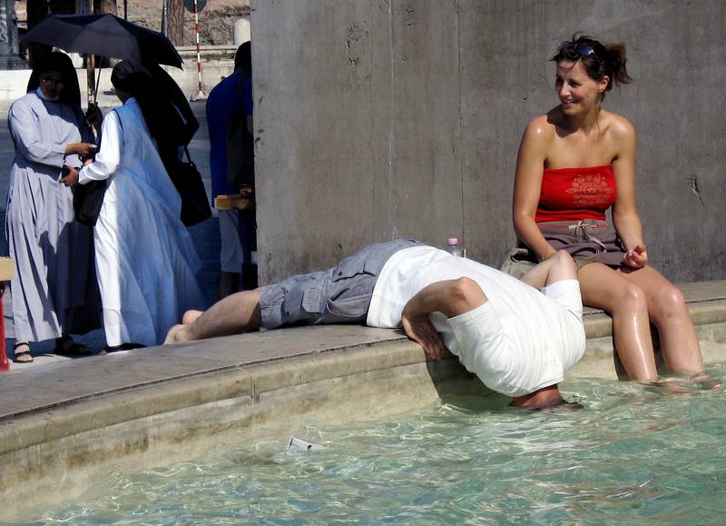 Tourists refresh themselves in the water of a fountain in Piazza Venezia in downtown Rome 26 June 2005, following the current heatwave in Italy and elsewhere in Europe. Northern Italy is affected by a heatwave which would  perdurer the next days . Several cities started their alarm from level two to three,  so can mobilizing the services of civil protection to come assistance to old people, most vulnerable by the heat that the temperature reached 34°C degrees.  AFP PHOTO/ Vincenzo PINTO