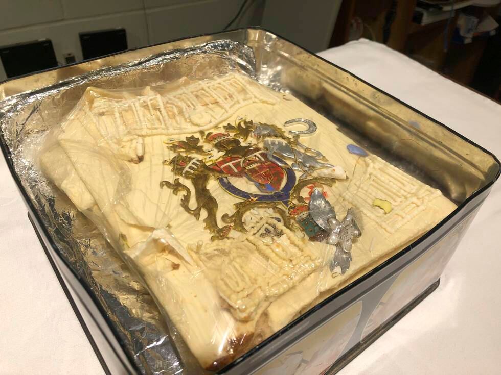 Kakestykket er dekket av et marsipanlag og pyntet med Windsor-slektens våpenskjold i gull, sølv, rødt og blått. Foto: Claire Hayhurst/PA via AP / NTB