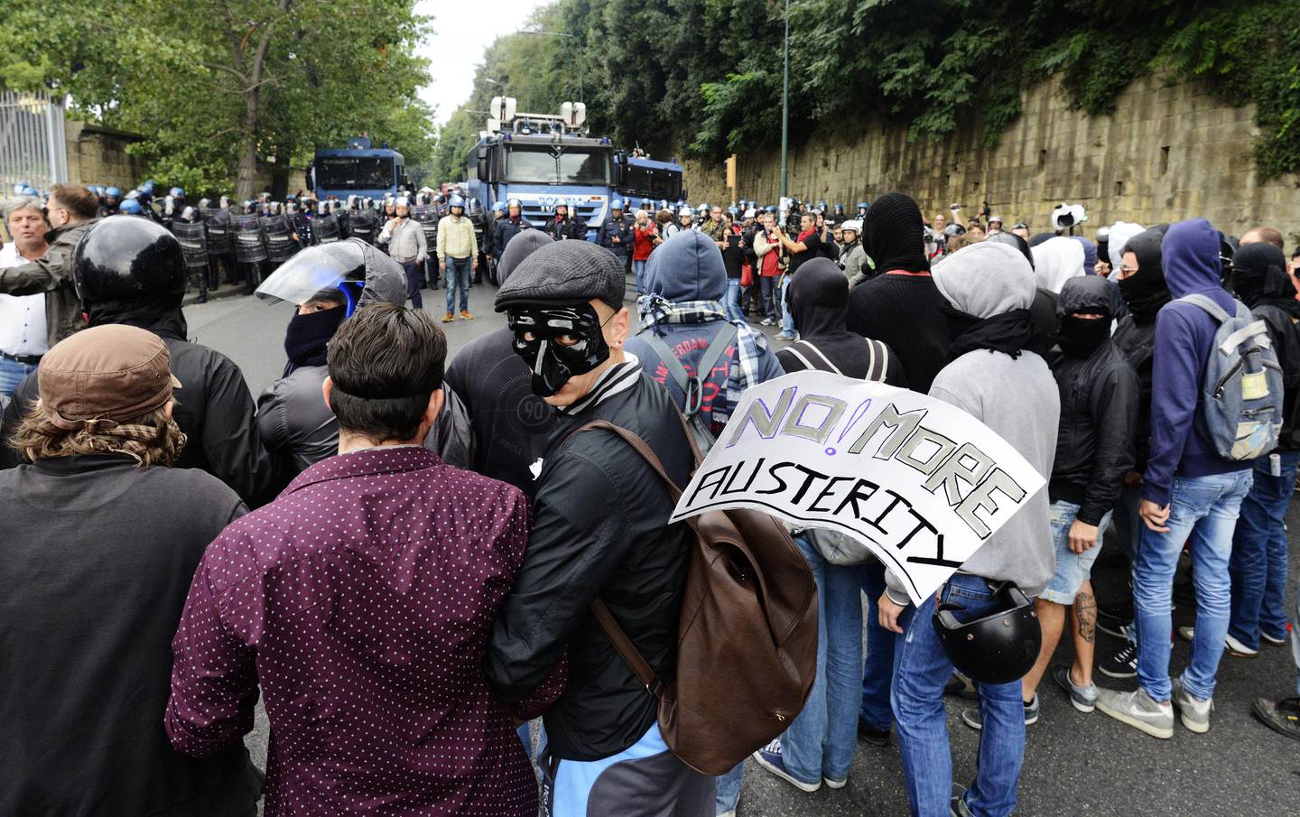 Demonstrators face police as the ECB governing council meets in Naples, Italy, Thursday, Oct. 2, 2014. European Central Bank head Mario Draghi is expected Thursday to underline the bank's willingness to deploy more economic stimulus measures, a stance that could send the euro skidding even lower. And a drop in the currency ó which helps eurozone exporters and could nudge up worryingly low inflation ó might be the most effective stimulus to come out of the ECB's monthly meeting. police squared off against more than 3,000 demonstrators in Naples, where the council held its monthly meeting, one of two held annually away from its headquarters in Frankfurt, Germany. Riot police used water cannons to break up protesters carrying banners against government austerity policies and unemployment. (AP Photo/Salvatore Laporta) / TT / kod 436