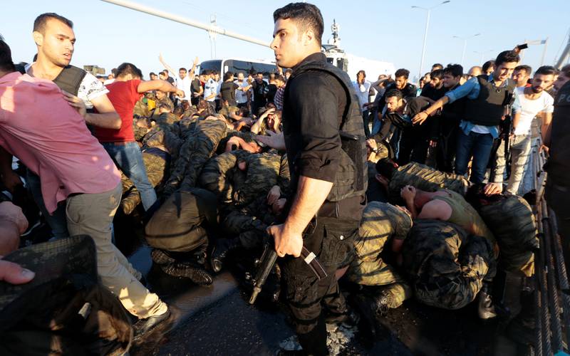 Lynsjestemning: En politimann beskytter tyrkiske soldater fra folkemengden etter det mislykkede kuppforsøket fredag kveld. FOTO: NTB SCANPIX