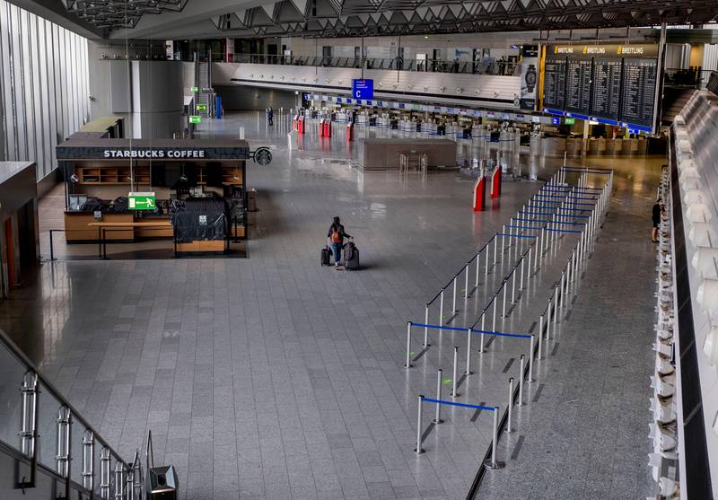A passenger walks alone at the airport in Frankfurt, Germany, Thursday, April 9, 2020. Due to the coronavirus about 95 percent of the flights had to be cancelled. The new coronavirus causes mild or moderate symptoms for most people, but for some, especially older adults and people with existing health problems, it can cause more severe illness or death. (AP Photo/Michael Probst)