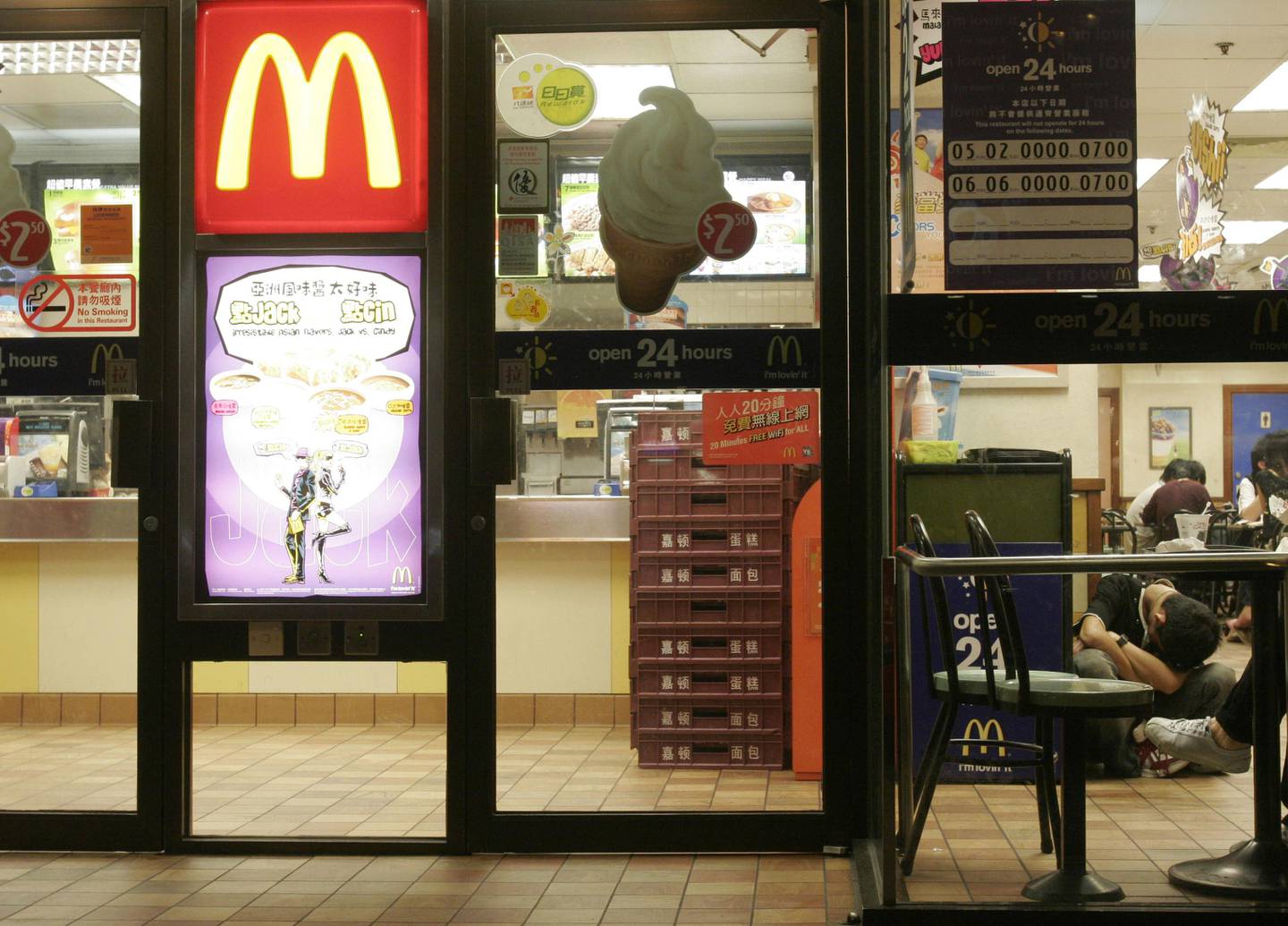 A man rests inside a downtown McDonald's in Hong Kong early Tuesday, May 1, 2007. McDonald's in Hong Kong is no longer just a restaurant for people to munch a burger, it has recently become a shelter for "McRefugees" to crash out. People who cannot afford high rent or want to save a few bucks from overnight transportation have opted to sleep in some of the fast food restaurants which operate around the clock. (AP Photo/Vincent Yu)