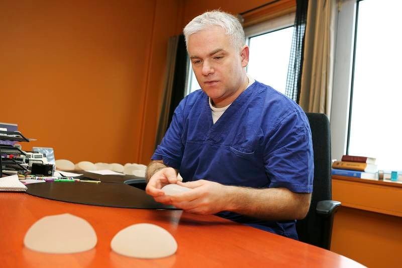 Lars Berg-Larsen opererte godt over 800 mennesker i 2013. Her med silikonimplantat på arbeidspulten. Foto: Frode Olsen