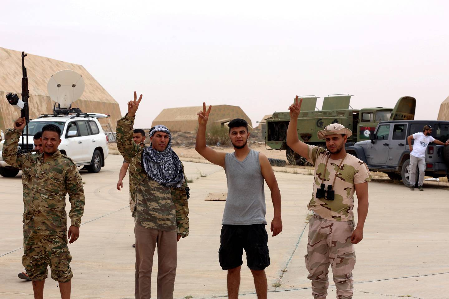 FILE PHOTO: Members of Libya's internationally recognised government flash victory signs after taking control of Watiya airbase, southwest of Tripoli, Libya May 18, 2020. REUTERS/Hazem Ahmed/File Photo