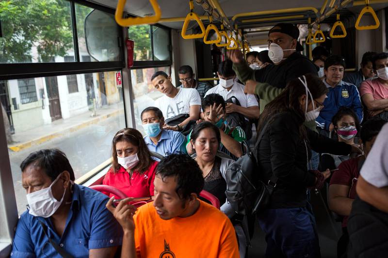 Passengers wearing protective masks ride on a public bus in Lima, Peru, Thursday, March 19, 2020, the fourth day of a state of emergency decreed by the government due to the new coronavirus outbreak. The vast majority of people recover from COVID-19. (AP Photo/Rodrigo Abd)
