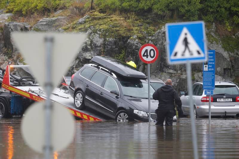 Parkeringsplassen ved Lørenskog stasjon er full av vann og biler. Nedbøren skaper problemer for biler. Foto: Vidar Ruud / NTB scanpix