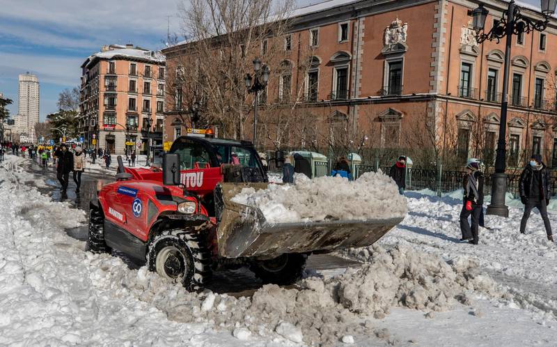 A plough clears snow in downtown Madrid, Spain, Sunday, Jan. 10, 2021. A large part of central Spain including the capital of Madrid are slowly clearing snow after the country's worst snowstorm in recent memory. (AP Photo/Manu Fernandez)