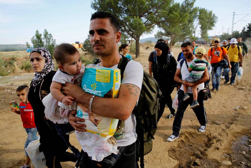 Disse syriske flyktninger på vei mot grensen mellom Hellas og Makedonia er blant de flere tusen som er på vei nordover i Europa. Presset mot å finne løsninger på krisen øker fra dag til dag. FOTO: YANNIS BEHRAKIS/NTB SCANPIX