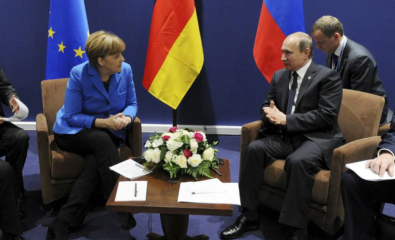 Tysklands forbundskansler Angela Merkel i uformelle samtaler med Russlands president Vladimir Putin. FOTO: NTB SCANPIX