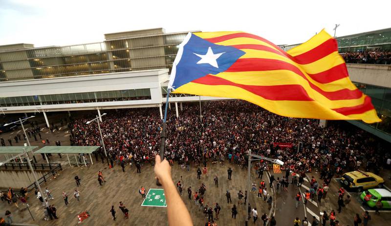 En demonstrant vifter med et katalansk flagg på Barcelonas flyplass El  Prat mandag, der mange møtte opp for å markere motstand mot dommene mot katalanske politikere. FOTO: JON NAZCA/NTB SCANPIX