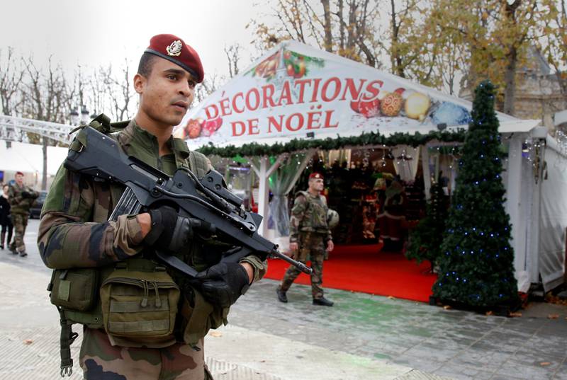 Franske soldater er synlig i bybildet i Paris. Her en fransk soldat foran en julebod på Champs-Élysées. FOTO: NTB SCANPIX