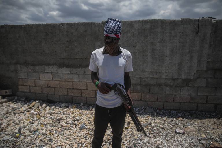 Et væpnet gjengmedlem poserer for kamera i et slumområde i Port-au-Prince.