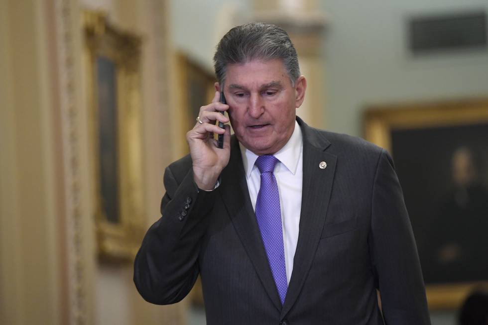 Sen. Joe Manchin, D-W.Va., talks on his phone as he walks on Capitol Hill in Washington, Monday, Feb. 3, 2020, before the continuation of the impeachment trial of President Donald Trump. (AP Photo/Susan Walsh)