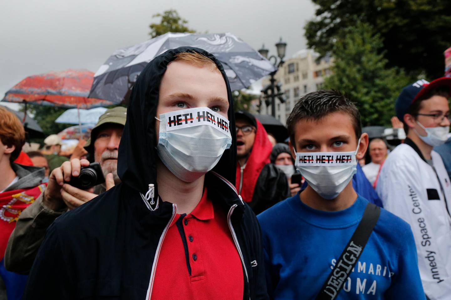 People gather to collect signatures to cancel the results of voting on amendments to the Constitution in Moscow, Russia, Wednesday, July 15, 2020. Writing on the face masks reads "no". Earlier this month a group of opposition activists called for a protest against the constitutional reform that allows Russian President Vladimir Putin to stay in power until 2036. (AP Photo/Alexander Zemlianichenko)