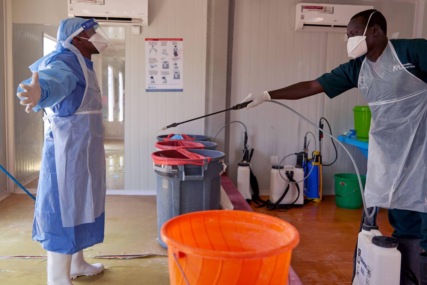 A doctor of International Medical Corps (IMC) is disinfected at the isolation ward of Ministry of Health Infectious Disease Unit in Juba, South Sudan, on April 24, 2020. - The national facility hosts South Sudan�s fifth case of the COVID-19 Coronavirus, who was admitted yesterday. (Photo by Alex McBride / AFP)
