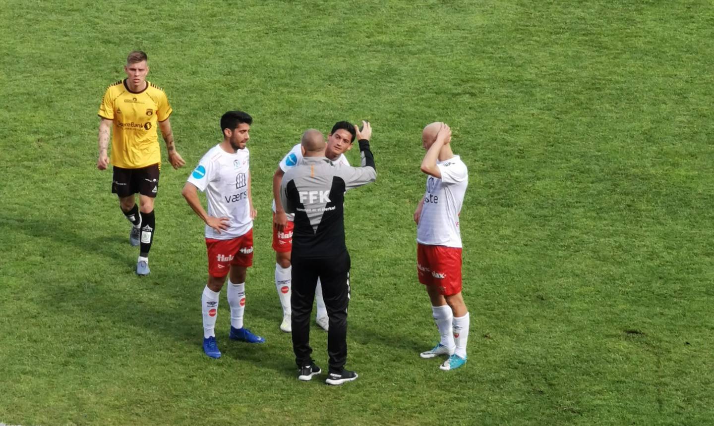 TOMÅLSSKÅRER: FFK-angriper Kjell Rune Sellin (2 fra høyre), som her får instrukser i pausen fra Kasey Wehrmann med fortid som spiller i begge klubber, nå assistenttrener i FFK.
