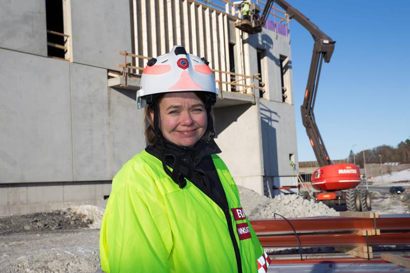 Prosjektleder Lise Peterson i Rogaland brann og redning kan konstatere at Kruse Smith er godt i gang med bygging av stasjonen som skal sikre tunnelen i Stavanger-området bedre ved branner. Fasaden i bakgrunnen, som for øvrig skal kles med tre, vender mot sør.  Foto: Stein Roger Fossmo