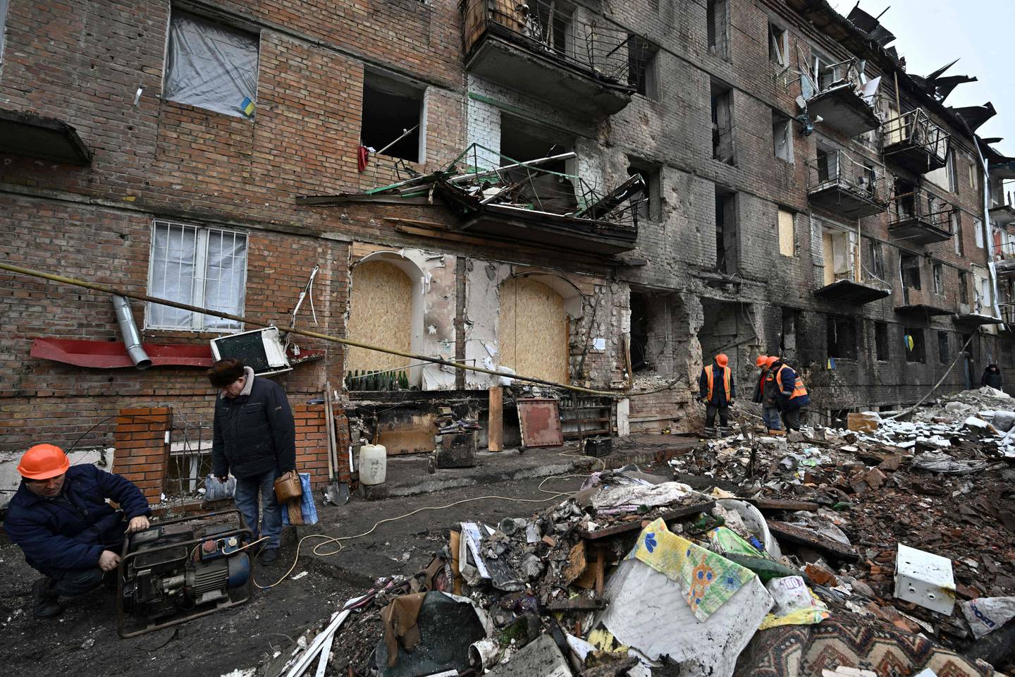 Arbeidsfolk på plass ved en ødelagt boligblokk i Vysjhorod i utkanten av Kyiv mandag 28. november.