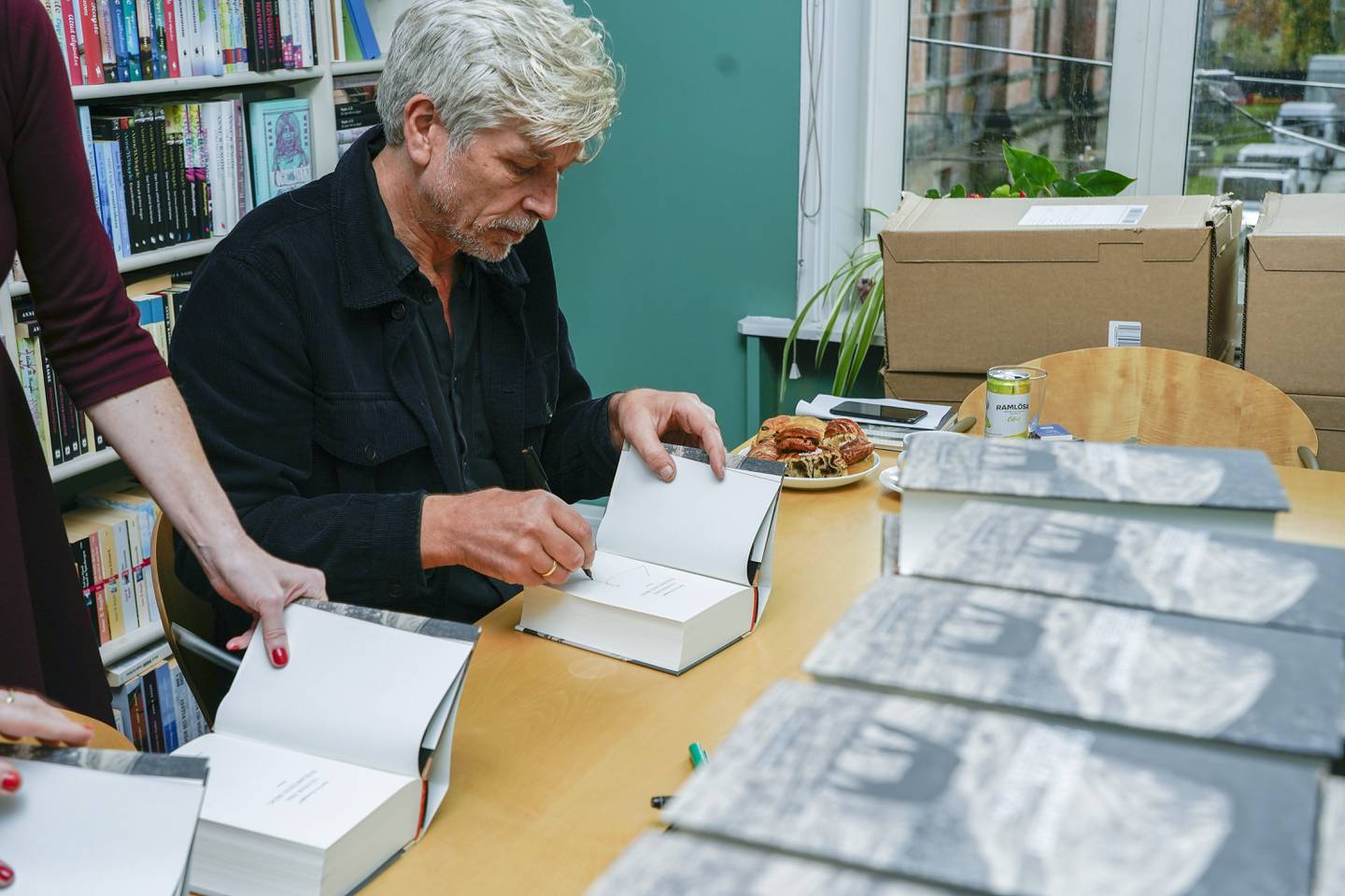 Boksignering er en del av en forfatters yrkesliv. Her er Karl Ove Knausgård i gang hos Forlaget Oktober. 
Foto: Terje Bendiksby / NTB
