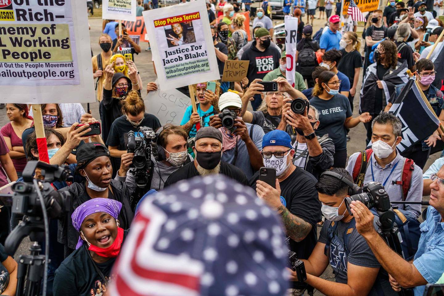 Protesters confront a Trump supporter (foreground) during a demonstration in front of the Kenosha, Wisconsin, Courthouse on September 1, 2020, during the visit of the US president amid ongoing protests after the shooting by police of Jacob Blake. - Trump said on a visit to protest-hit Kenosha, Wisconsin that recent anti-police demonstrations in the city were acts of "domestic terror" committed by violent mobs. (Photo by Kerem Yucel / AFP)