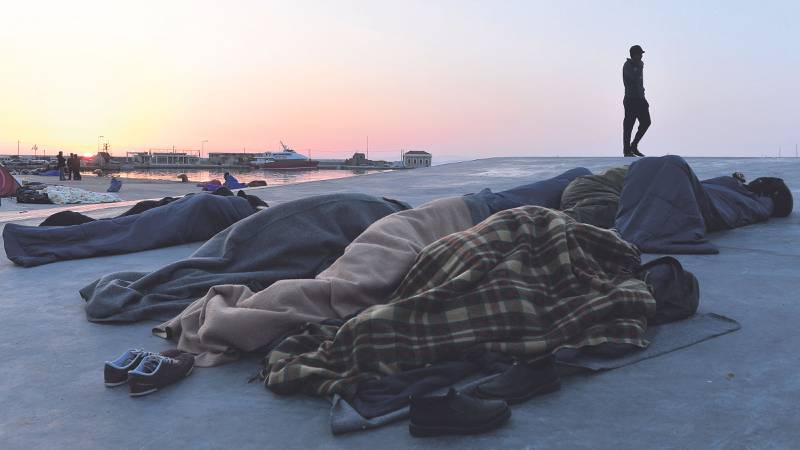 Flyktninger og migranter sover på havnen Chios, der returene til Tyrkia begynte denne uka.