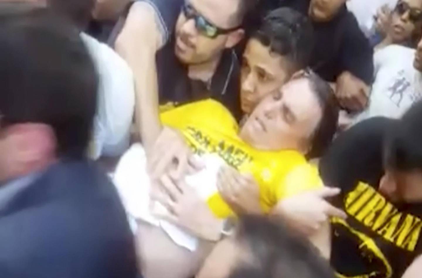 BEST QUALITY AVAILABLE - In this video still provided by Fernando Goncalves, National Social Liberal Party presidential candidate Jair Bolsonaro is carried away after being stabbed during a campaign rally in Juiz de Fora, Brazil, Thursday, Sept. 6, 2018. Officials and Bolsonaro's son said the far-right candidate was in stable condition, though the son also said Bolsonaro suffered severe blood loss and arrived to the hospital "almost dead." (AP Photo/Fernando Goncalves)