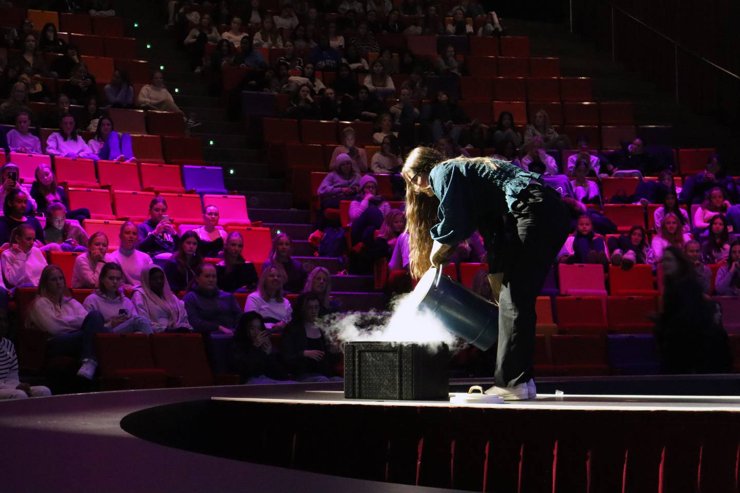 Girl containing transparent liquid nitrogen in a box on the string.
