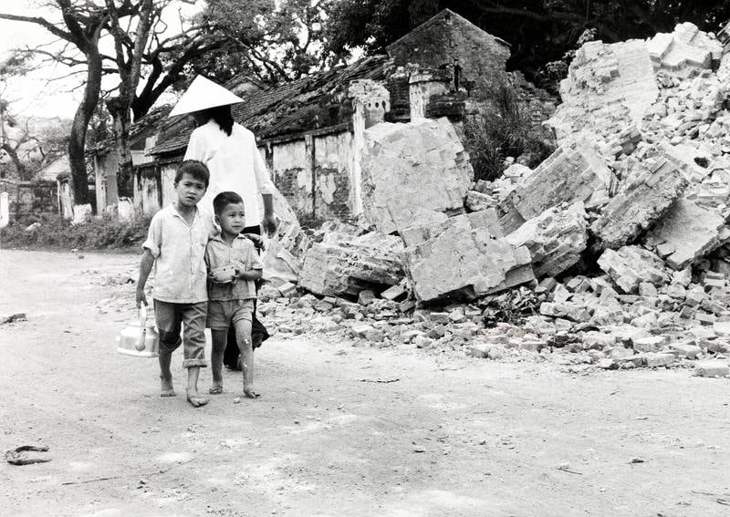 19. mai 1979: Folk har så smått begynt å vende tilbake til sine hjem i Lang Son, slik som disse to små guttene. Til høyre ruinene av en ødelagt kirke. FOTO: Erik Sagflaat