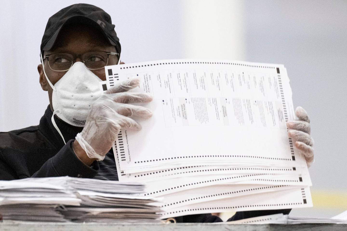 Workers sort and stack ballots in preparation for scanning during a recount, Tuesday, Nov. 24, 2020, in Lithonia, Ga. County election workers across Georgia have begun an official machine recount of the roughly 5 million votes cast in the presidential race in the state. The recount was requested by President Donald Trump after certified results showed him losing the state to Democrat Joe Biden by 12,670 votes, or 0.25%   (AP Photo/Ben Gray)