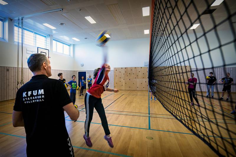 Adina Mevik (14) smasher ballen over nettet. I forgrunnen Per Arne Haarr fra KFUM volleyball, dagens instruktør. Foto: Roy Storvik