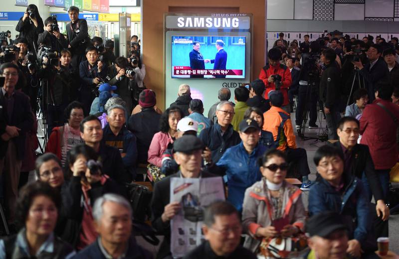 Folk på en jernbanestasjon i Seoul i Sør-Korea fulgte med på TV-skjermer under direktesending i går. 
