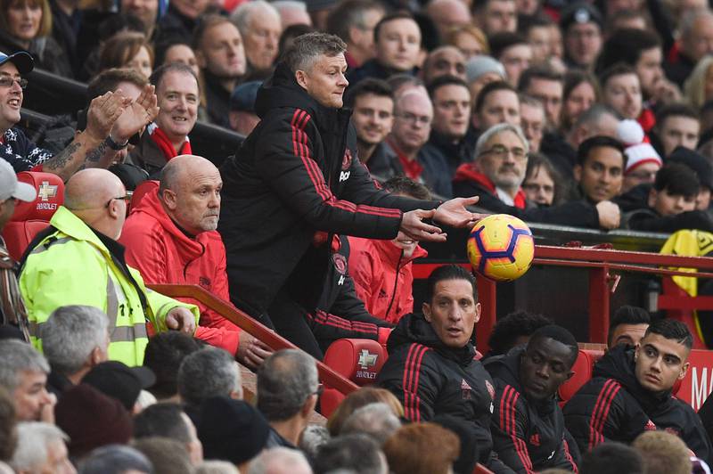 Manchester United's  Norwegian caretaker manager Ole Gunnar Solskjaer (C) throws a ball to the pitch during the English Premier League football match between Manchester United and Huddersfield Town at Old Trafford in Manchester, north west England, on December 26, 2018. (Photo by Oli SCARFF / AFP) / RESTRICTED TO EDITORIAL USE. No use with unauthorized audio, video, data, fixture lists, club/league logos or 'live' services. Online in-match use limited to 120 images. An additional 40 images may be used in extra time. No video emulation. Social media in-match use limited to 120 images. An additional 40 images may be used in extra time. No use in betting publications, games or single club/league/player publications. / 