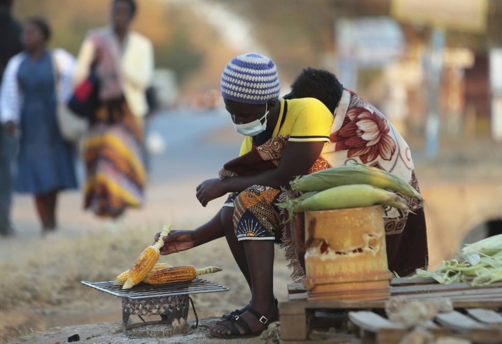 En kvinne selger grillede mailskolber på gata i Zambias hovedstad Lusaka.
