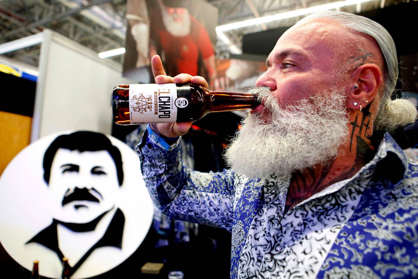A model drinks a beer of "El Chapo 701," a line in clothing, jewelry and liquor bearing the nickname of the jailed Mexican drug lord Joaquin "El Chapo" Guzman Loera, during the 72 edition of IM Intermoda Mexico fashion fair in Guadalajara, Mexico, on January 14, 2020. (Photo by Ulises Ruiz / AFP)