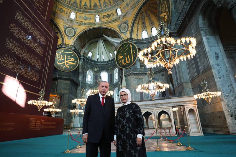 This handout picture released by the Turkish presidential press office on July 23,2020, shows Turkey's President Recep Tayyip Erdogan (L) and his wife Emine Erdogan (R) posing the Hagia Sophia mosque in Istanbul. - The first prayers at Hagia Sofiaa since the Istanbul landmark was reconverted to a mosque will take place on July 24, 2020. Turkey's top court paved the way for the conversion in a decision to revoke the edifice's museum status conferred nearly a century ago. The sixth-century building had been open to all visitors, regardless of their faith, since its inauguration as a museum in 1935. (Photo by Murat CETINMUHURDAR / TURKISH PRESIDENTIAL PRESS SERVICE / AFP) / RESTRICTED TO EDITORIAL USE - MANDATORY CREDIT "AFP PHOTO / TURKISH PRESIDENTIAL PRESS OFFICE / Murat CETINMUHURDAR - NO MARKETING NO ADVERTISING CAMPAIGNS - DISTRIBUTED AS A SERVICE TO CLIENTS