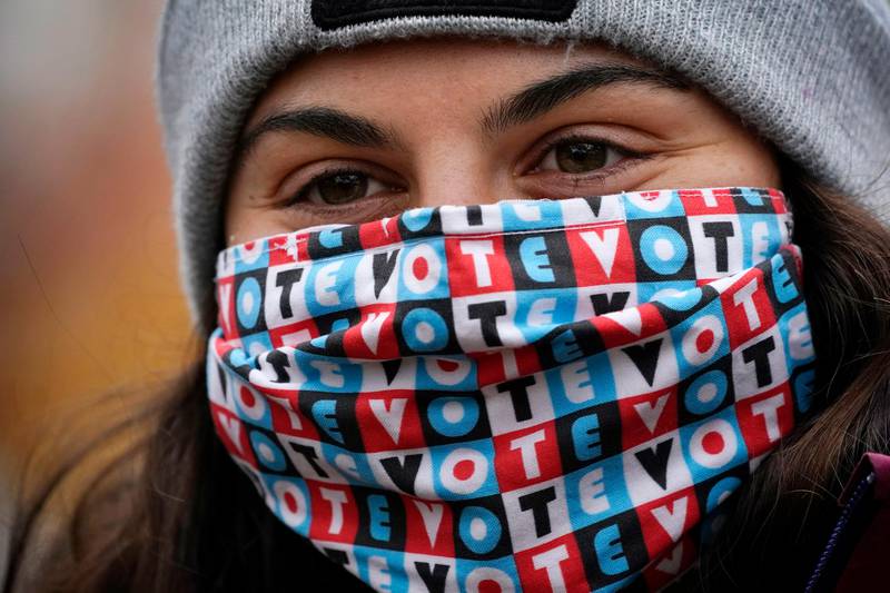 Zoe Wynn, a sophomore at Bates College, from Mill Valley, Calif., wears a mask to help prevent the spread of the coronavirus while attending a campaign event held by Democratic candidate for Senate, Sara Gideon, Friday, Oct. 30, 2020, in Lewiston, Maine. (AP Photo/Robert F. Bukaty)