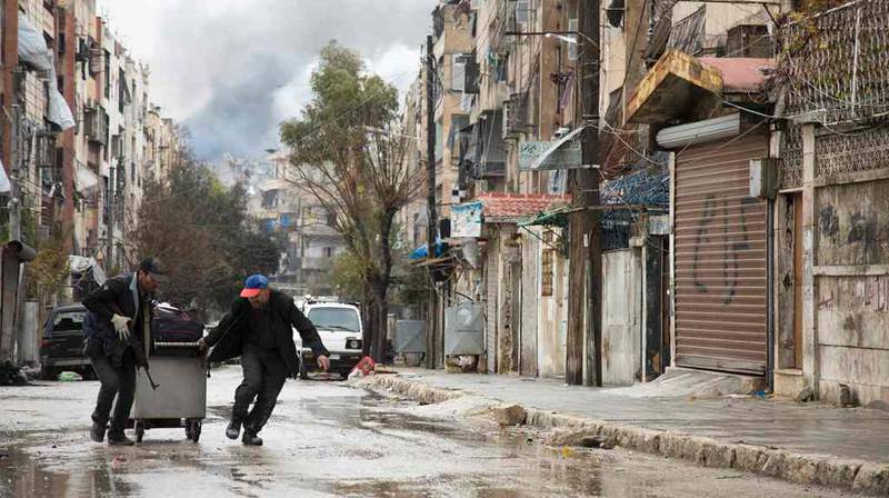 Røyk fra bombenedslag ses i bakgrunnen på dagen da sivile skulle evakueres fra Aleppo.