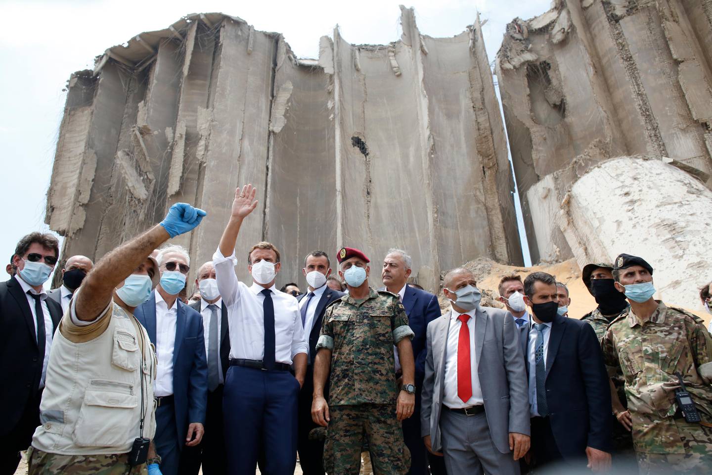 FILE - In this Aug. 6, 2020 file photo, French President Emmanuel Macron, center left, gestures as he visits the devastated site of the Aug. 4 explosion at the port of Beirut, Lebanon. An economic meltdown, a revolution, financial collapse, a virus outbreak and a cataclysmic explosion that virtually wiped out the country's main port. The past year has been nothing short of an earthquake for tiny Lebanon, with an economic meltdown, mass protests, financial collapse, a virus outbreak and a cataclysmic explosion that virtually wiped out the countrys main port. Yet Lebanese fear even darker days are ahead. (AP Photo/Thibault Camus, Pool, File)